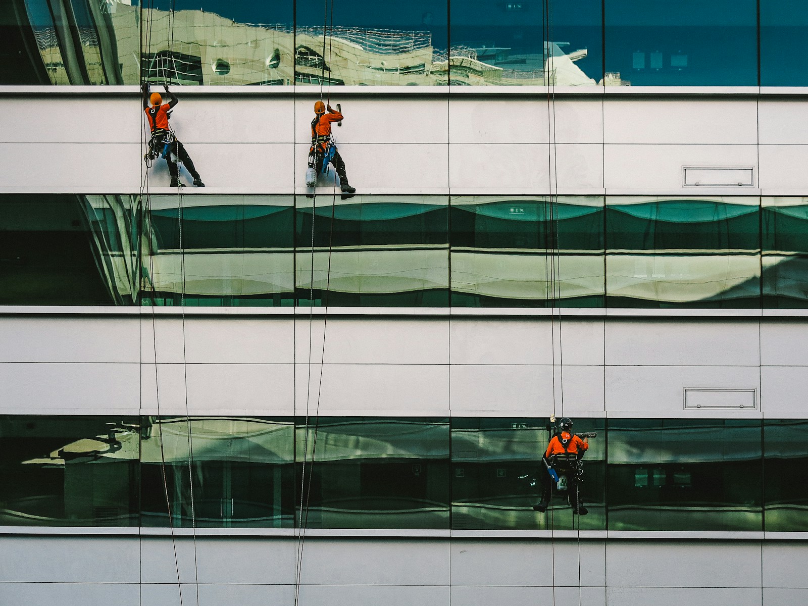 Photo by Nuno Silva man cleaning white building
